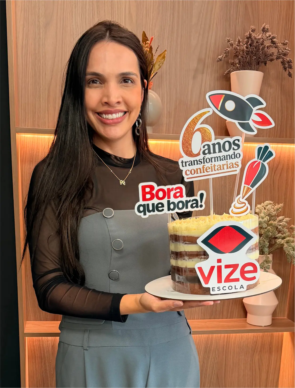 Fundadora da Vize segurando o bolo comemorativo dos 6 anos